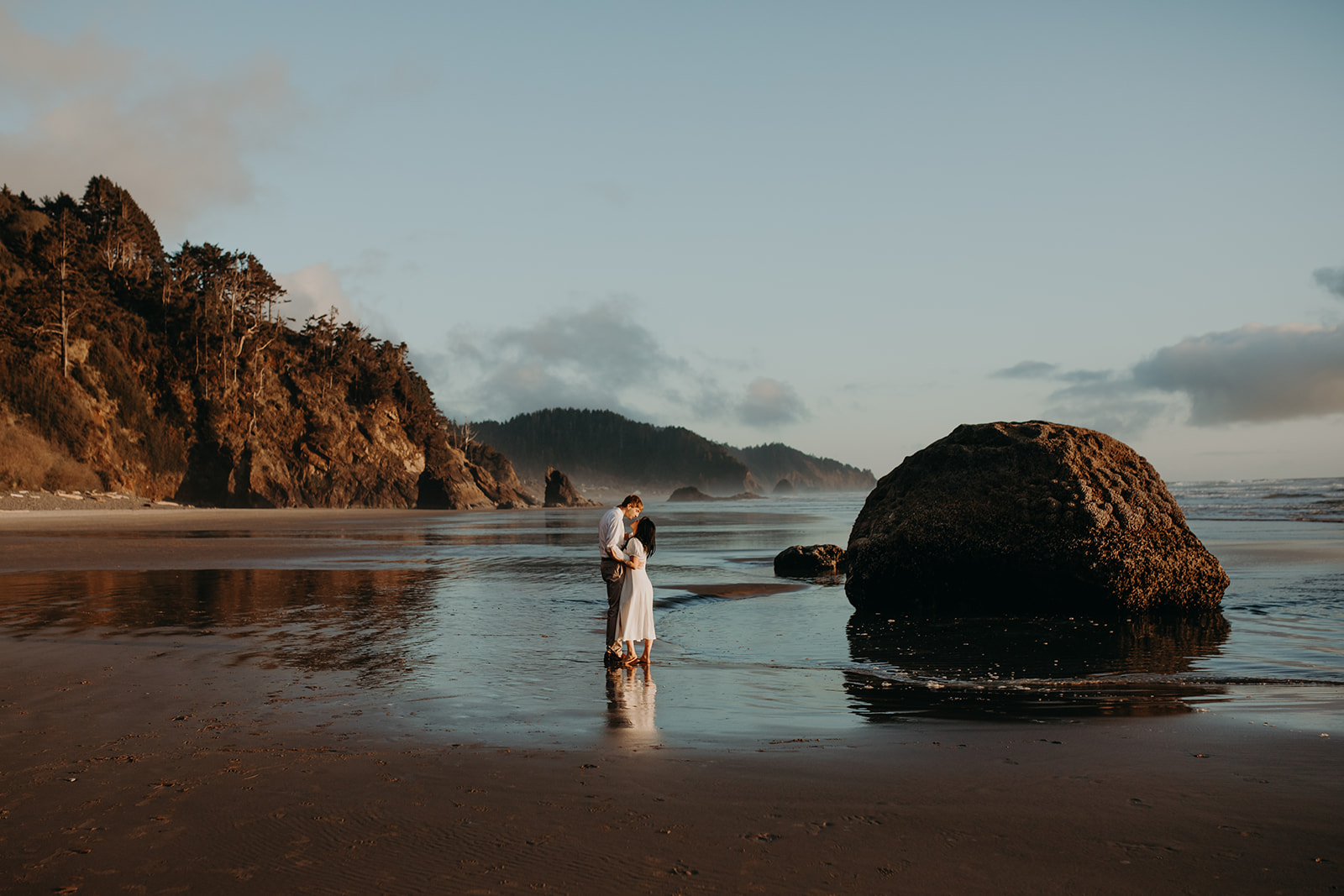 Man and woman kissing at Canon Beach on the Oregon Coast