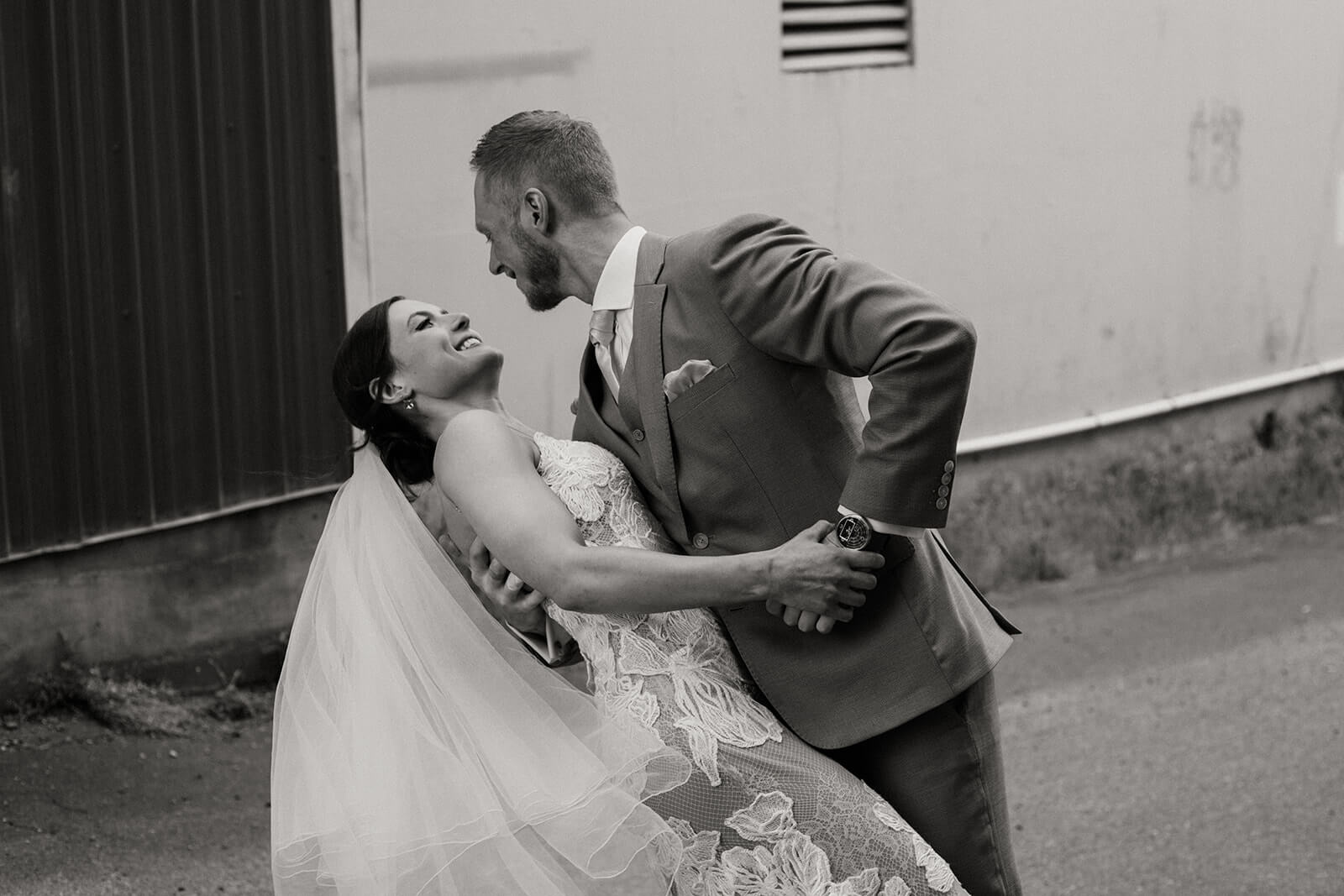 Groom dips bride back for couple portraits at industrial wedding