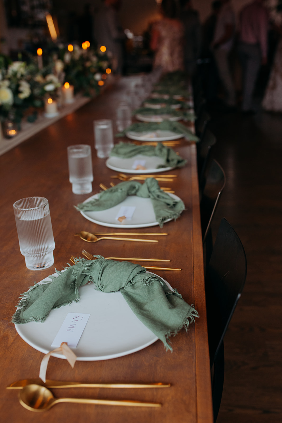 Intimate wedding reception table with green napkins and white plate settings