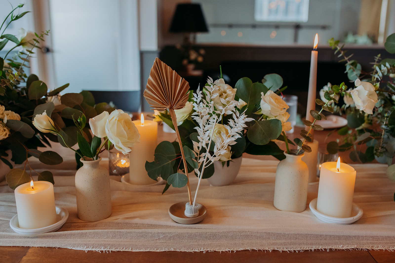 White and green florals and candles for industrial wedding reception