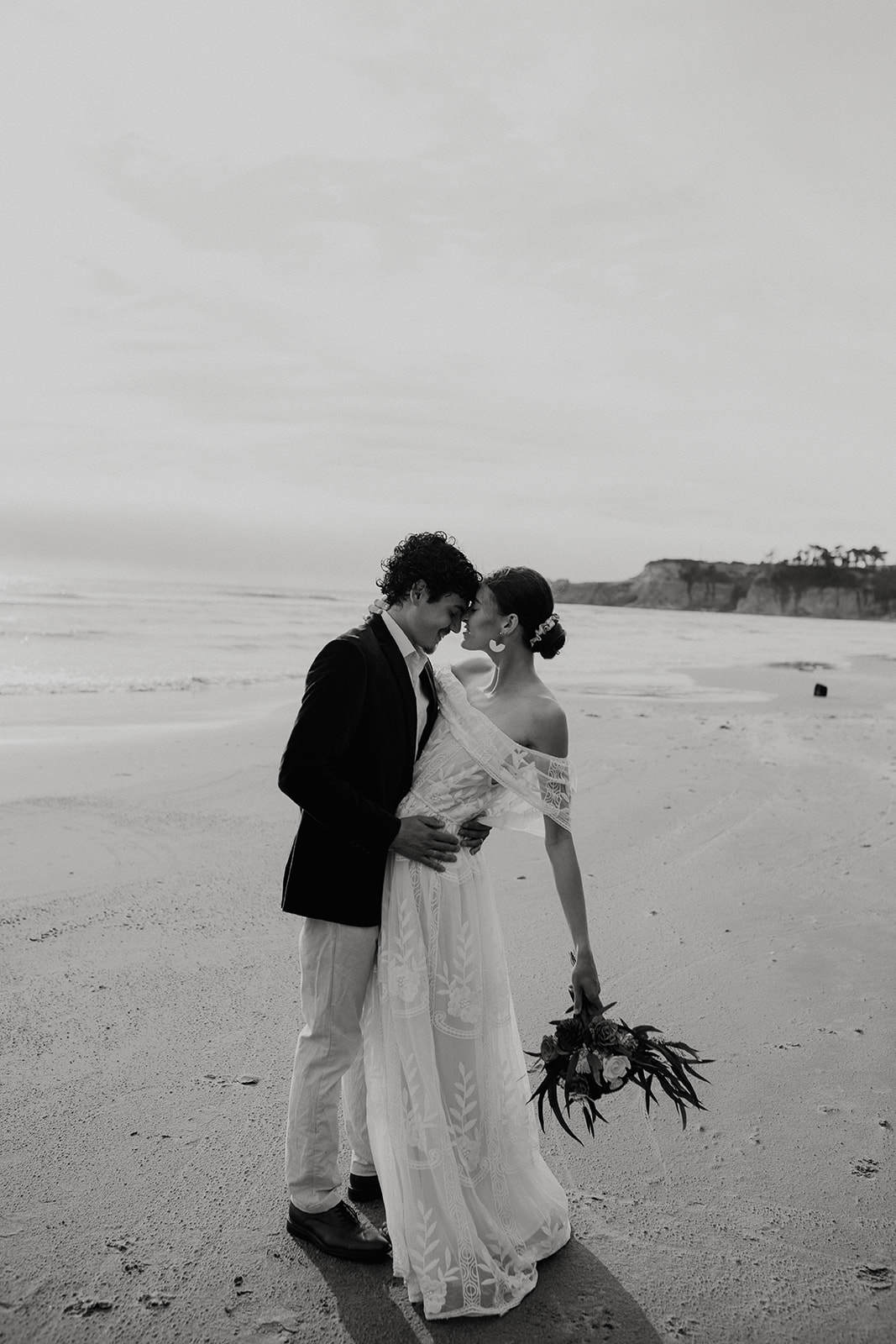 Bride and groom kissing on the beach at Devil's Punchbowl