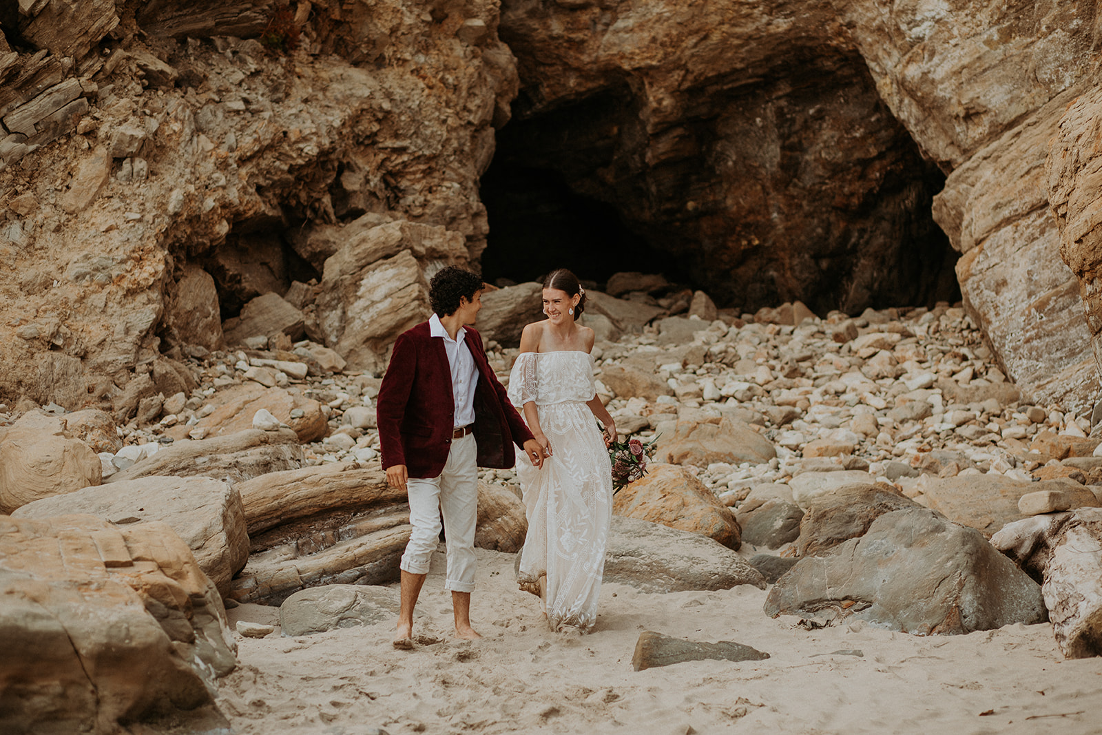 Bride and groom holding hands walking along the beach for their Oregon Coast elopement
