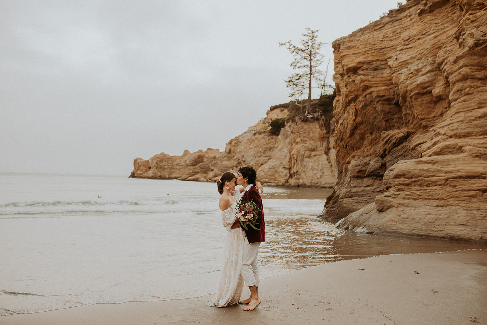 Bride and groom kissing on the beach for their Oregon Coast elopement