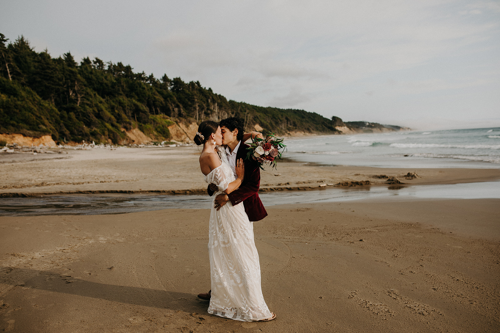 Bride and groom kissing on the beach at Devil's Punchbowl