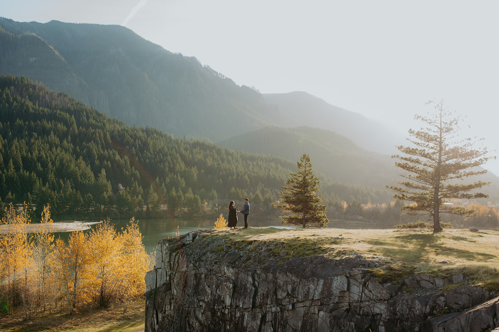 Couple standing on the edge of a cliff at engagement session at cascade locks