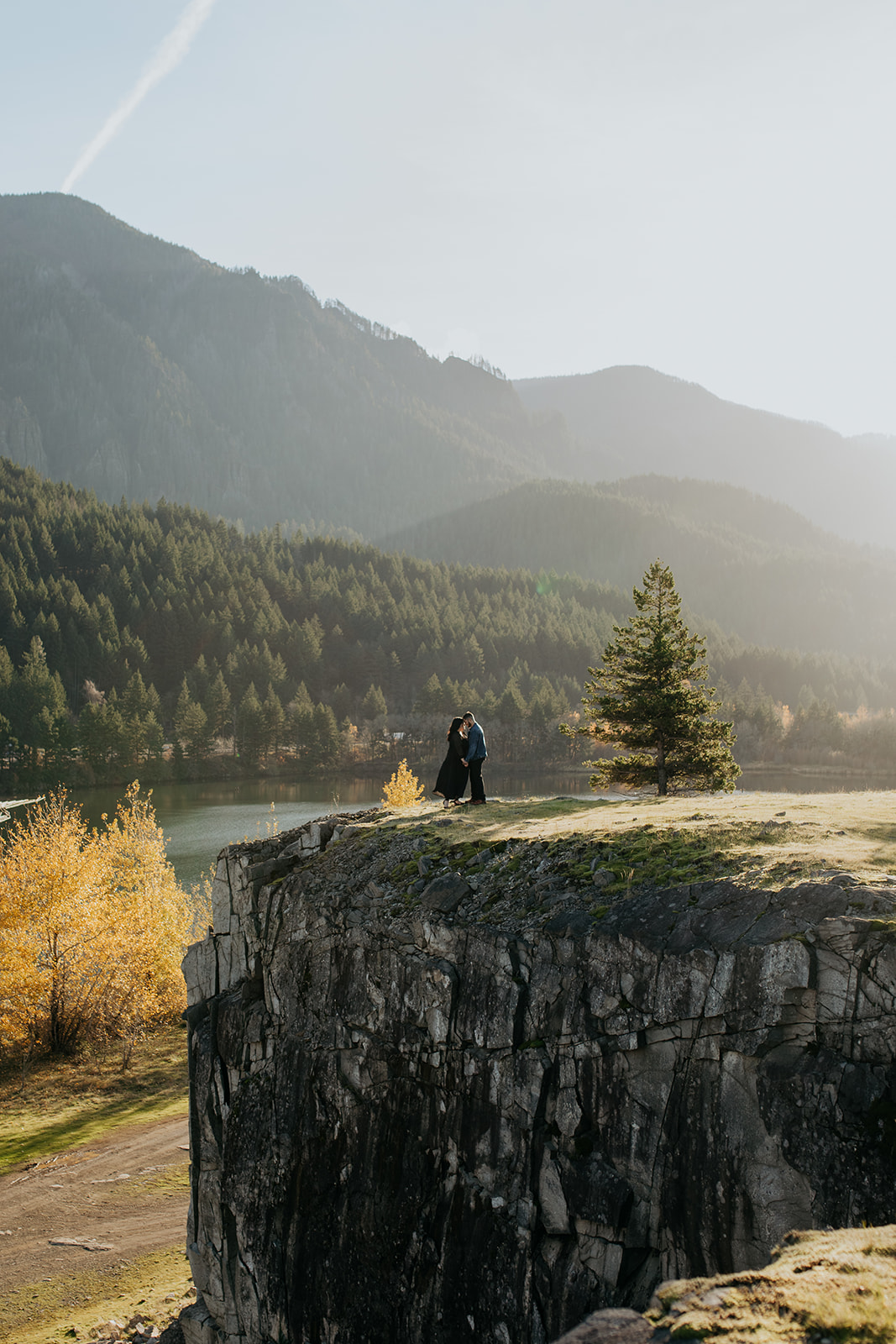 Couple standing on the edge of a cliff at engagement photography session at cascade locks