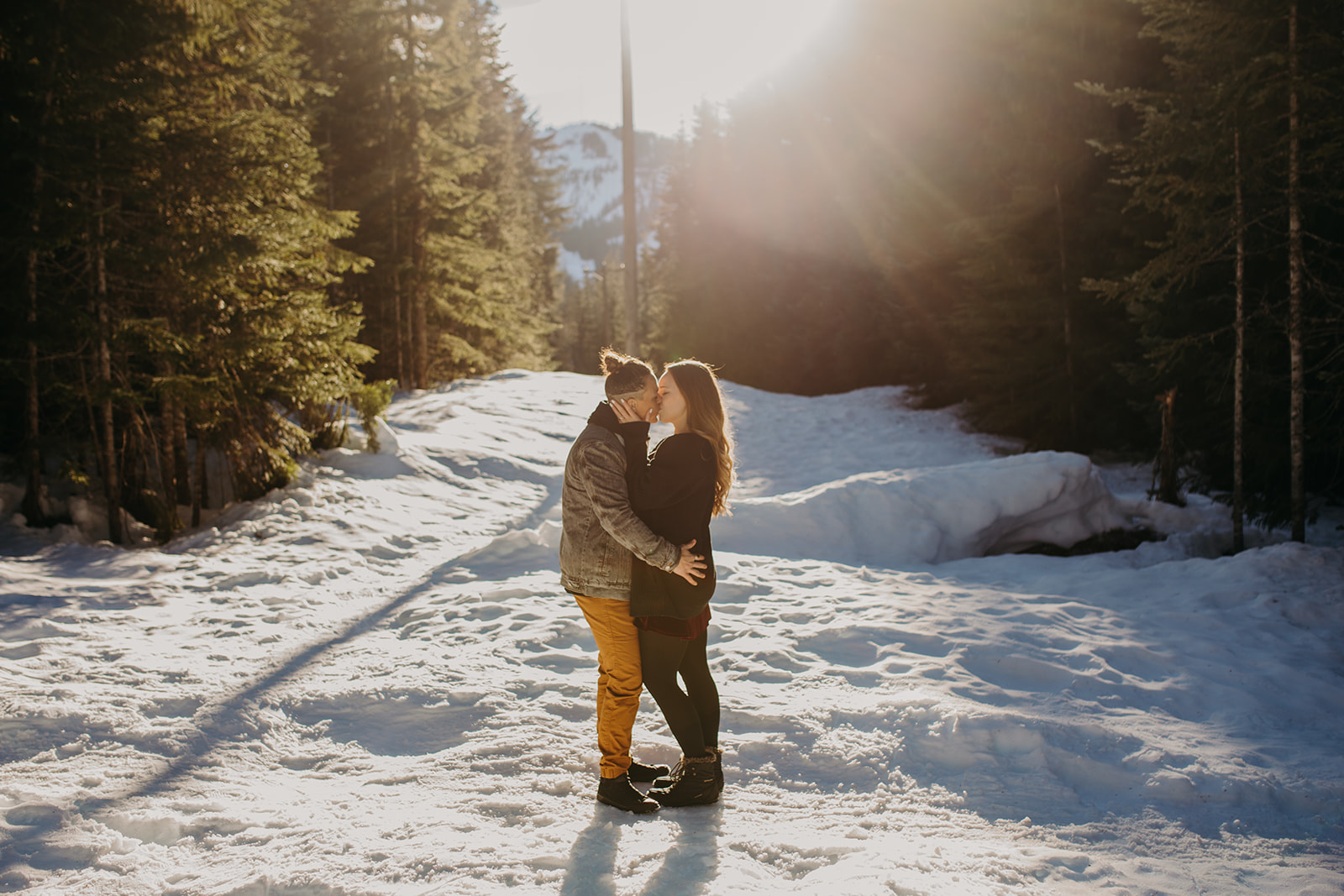 Two women standing forehead to forehead in the snow for engagement photo session
