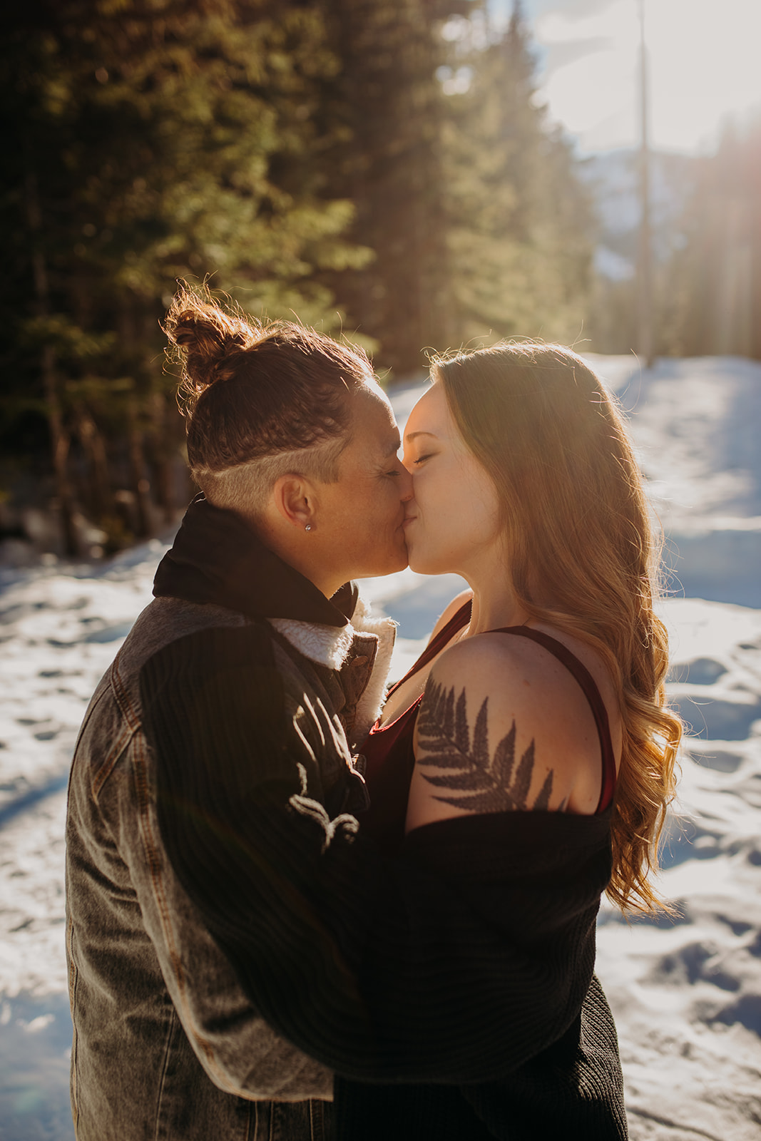 Two women kissing in the snow during engagement session