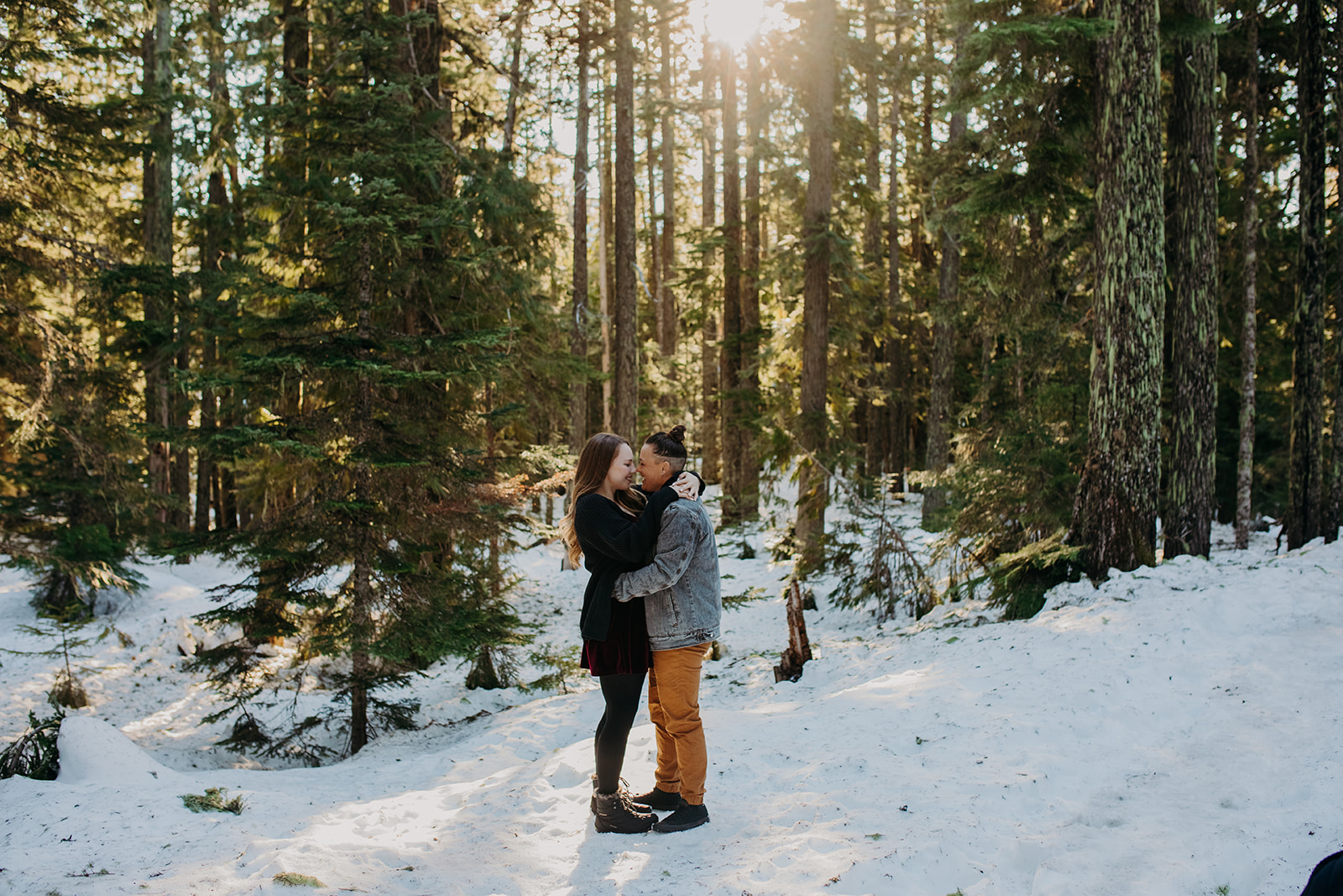 Two women kissing in the snow during snowy engagement photos