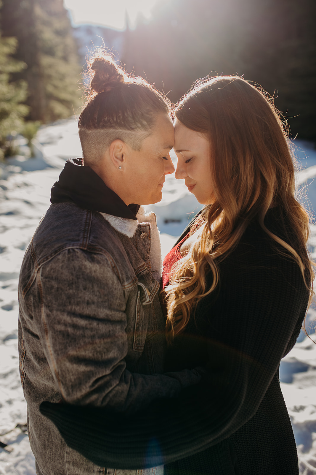 Two women standing forehead to forehead for engagement photos