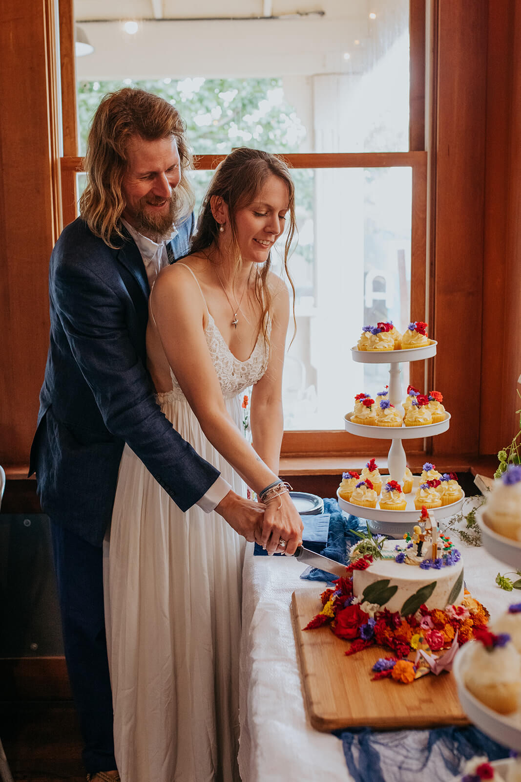 Bride and groom cut cake during microwedding reception