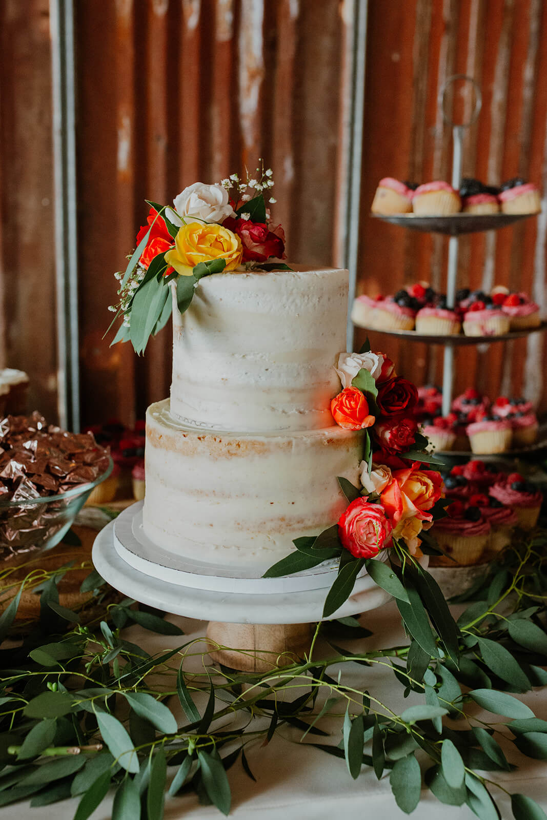 White wedding cake with peach, white, and yellow flowers
