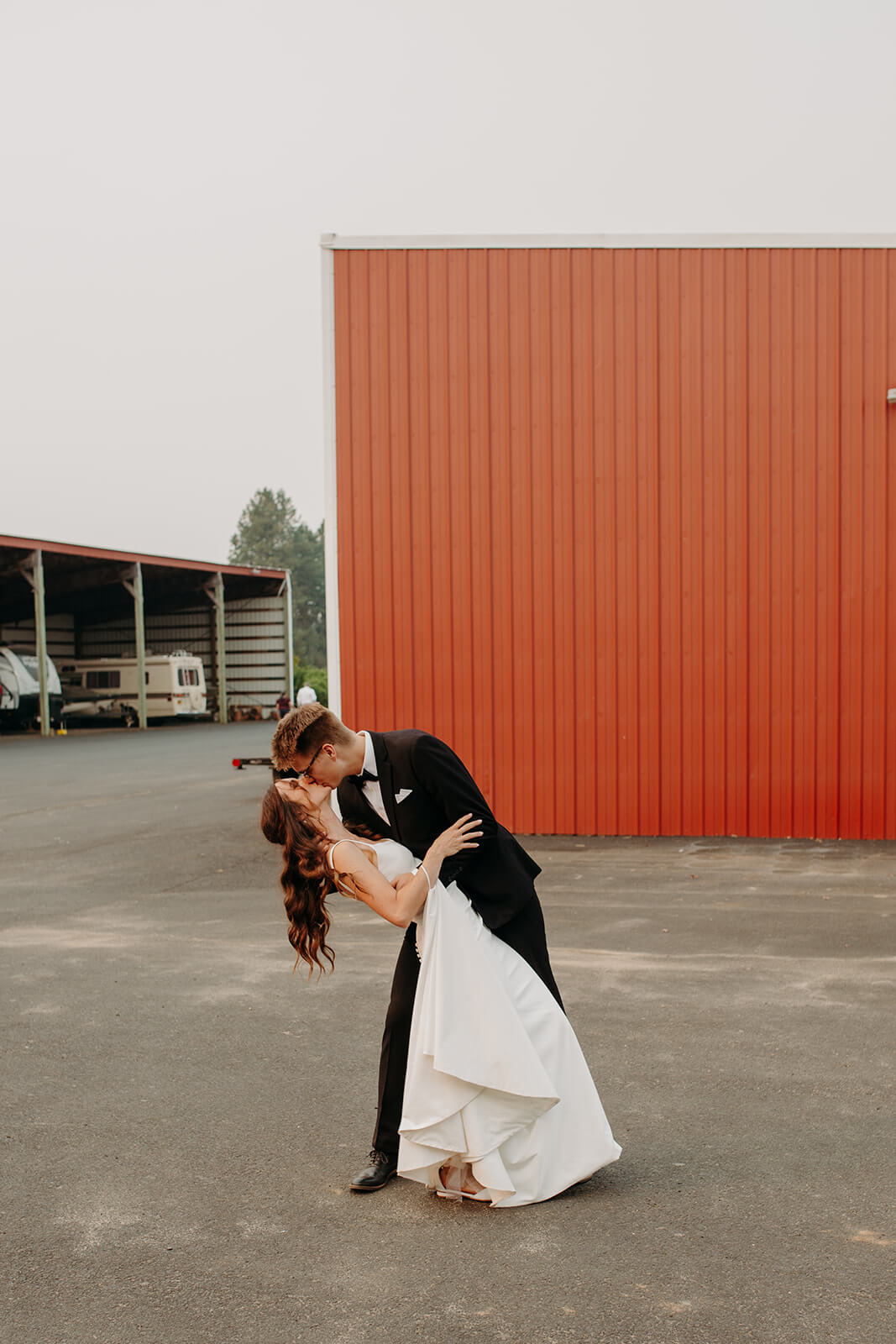 Bride and groom kiss as they enter wedding reception on Oregon family farm