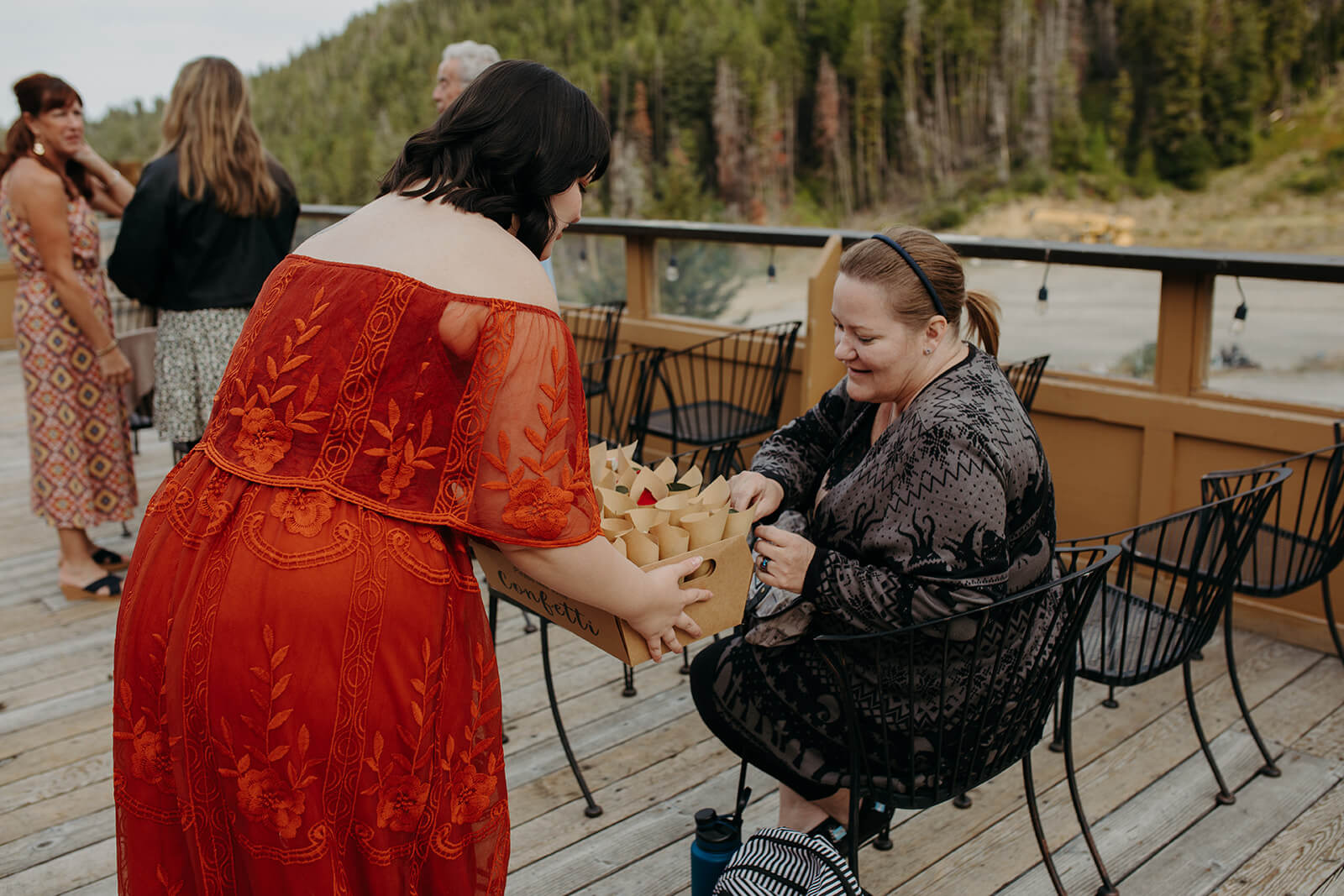 Guest passing out wedding favors at ski lodge wedding ceremony