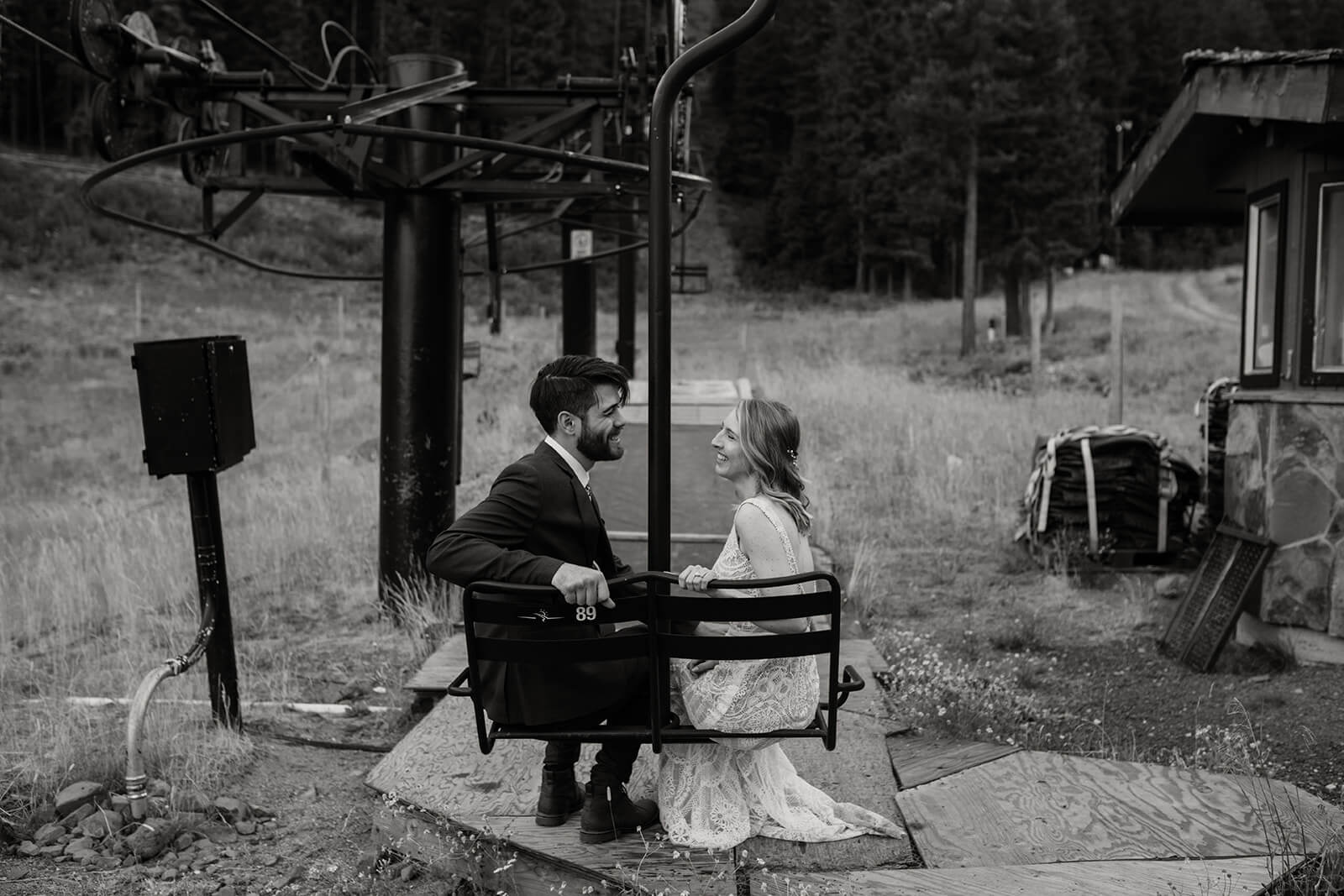 Bride and groom sitting on a ski lift for sunset couple portraits