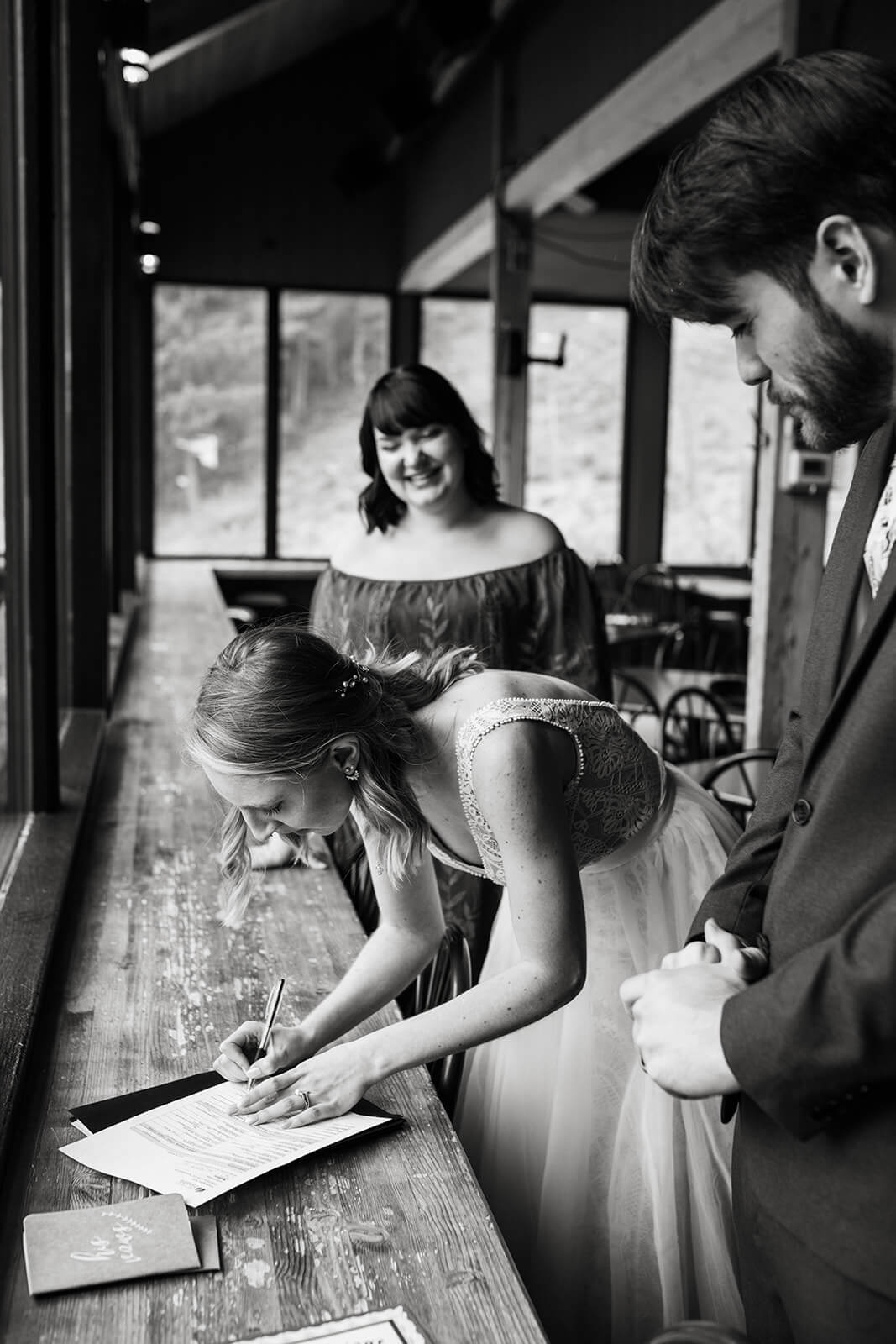 Bride signing marriage license at ski wedding