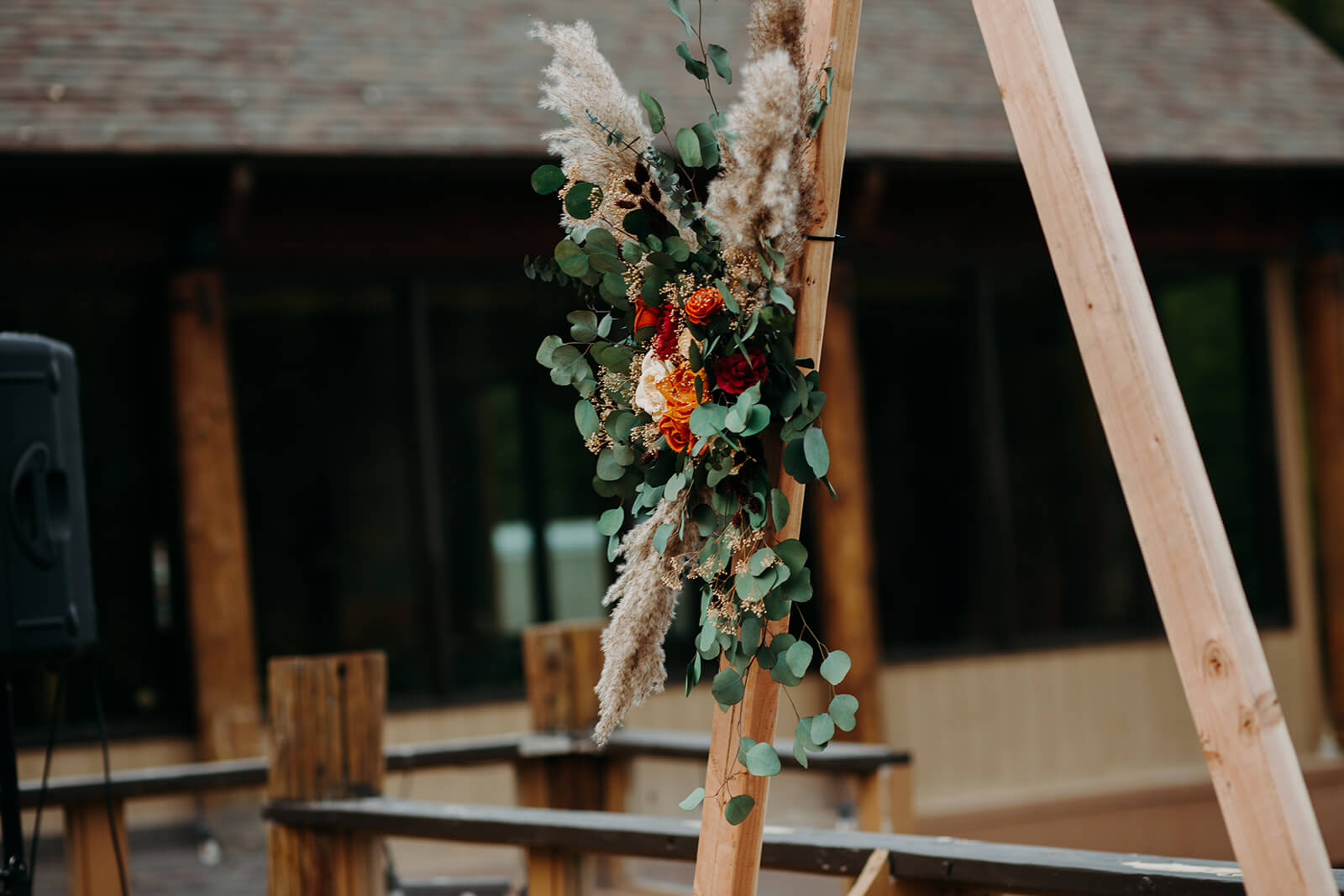Orange, cream, and green florals on wood wedding arch