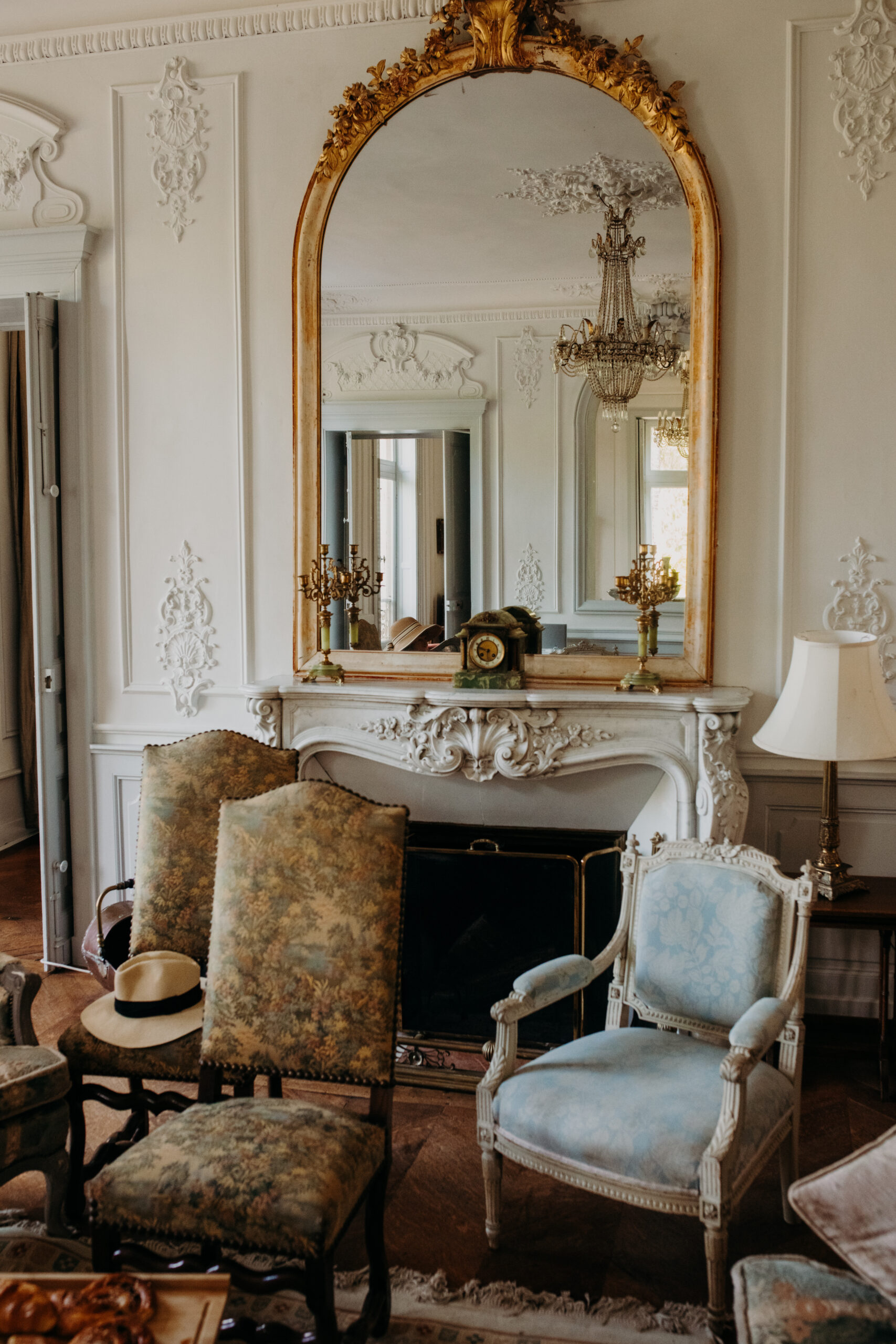 Interior room decorated with chairs and large ornate mirror in a french chateau. 