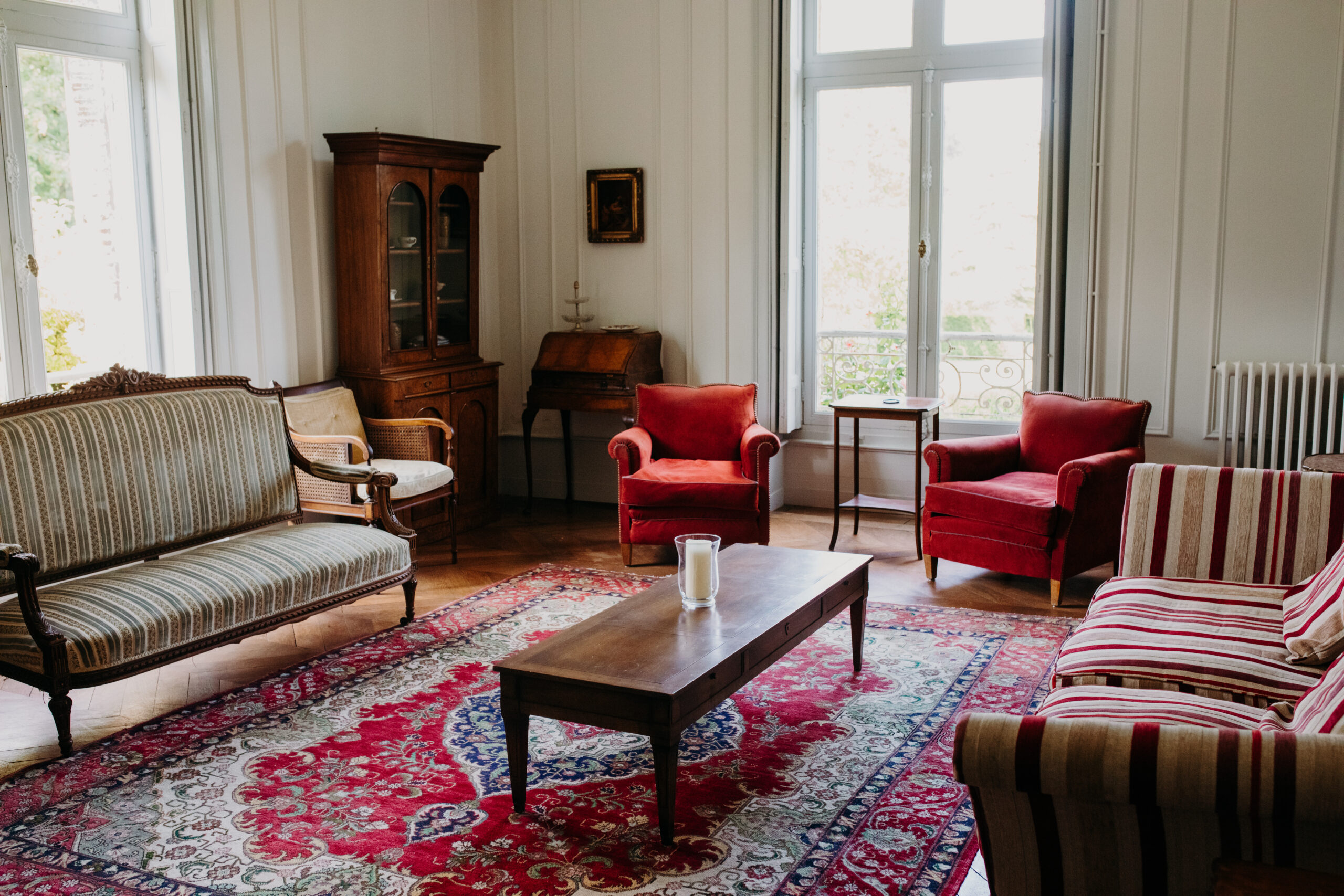 Interior view of french chateau with sofas and chairs and Moroccan rug. 