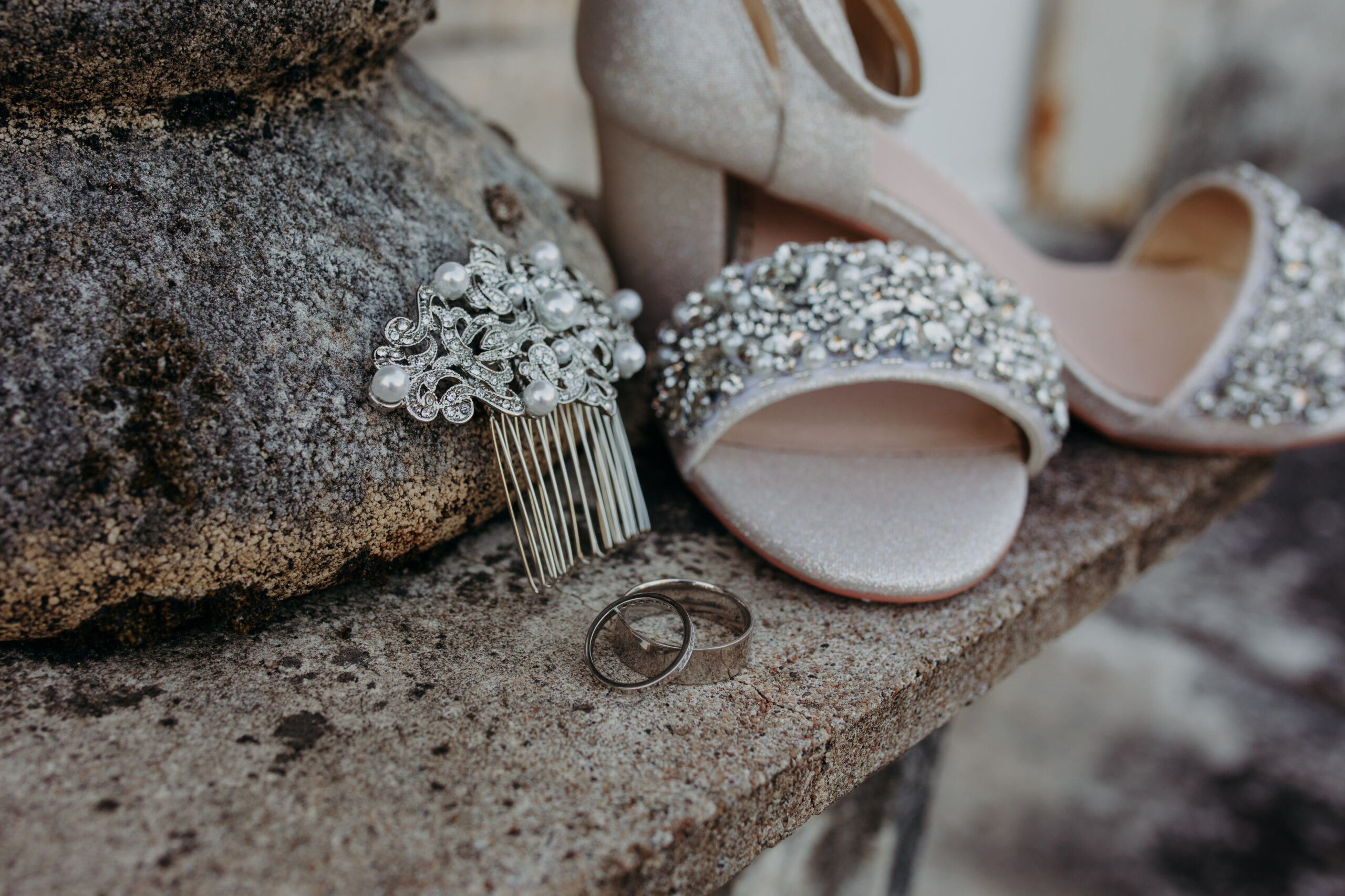 a hair pin, rings, and heels are displayed outside on a stone plinth
