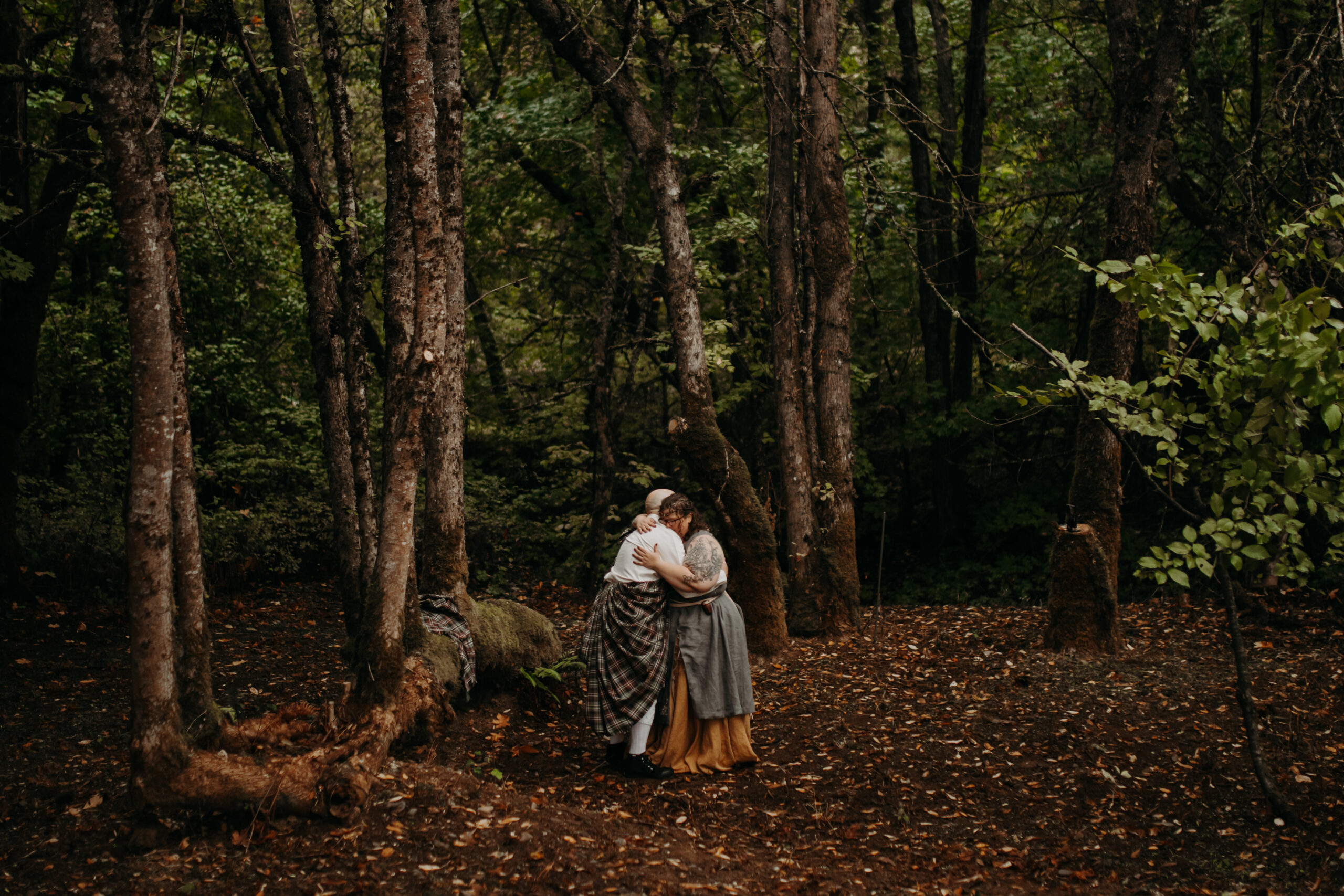 man and woman embrace in forest