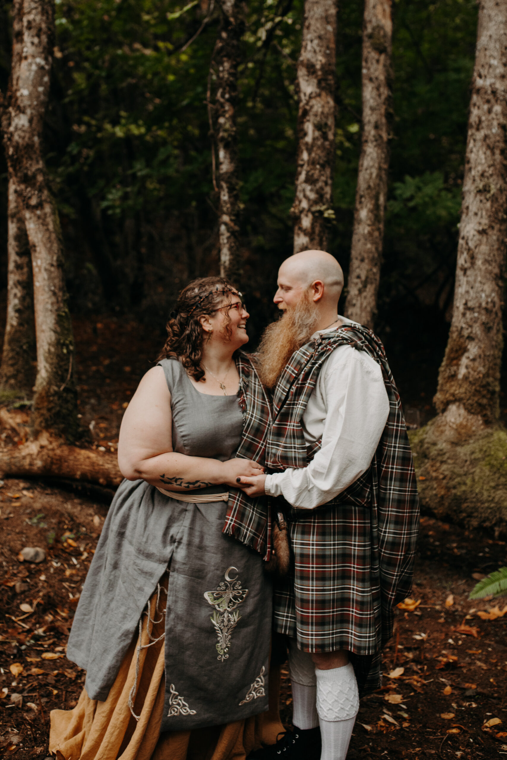 man and woman stare lovingly at each other in forest