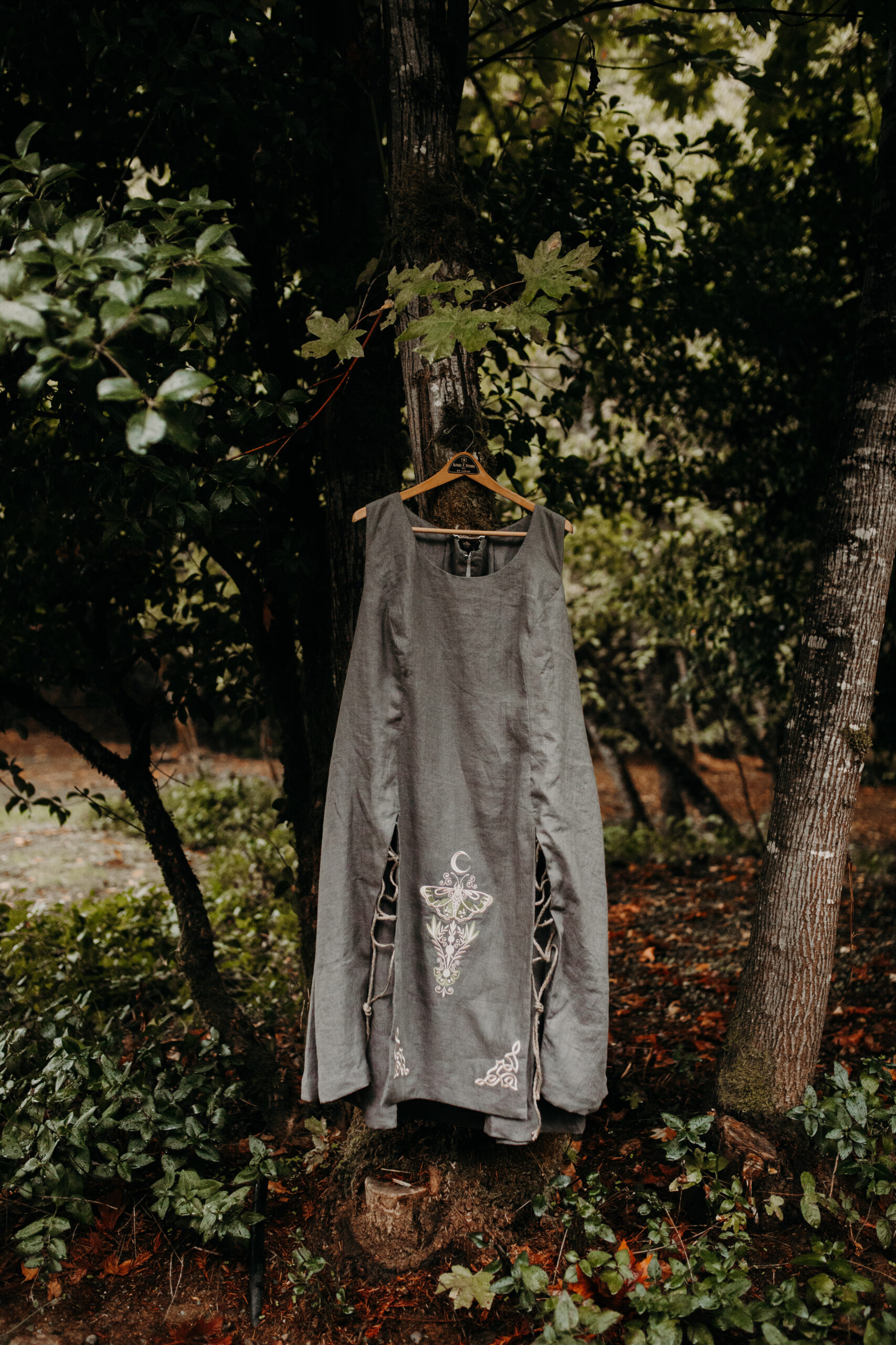 grey dress with white lunar moth design hangs from tree in Medford Oregon