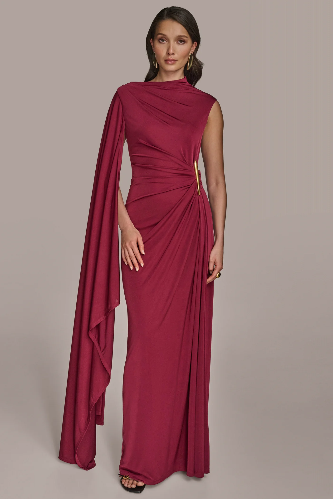 woman stands in a floor length wine red evening gown for black tie dress code