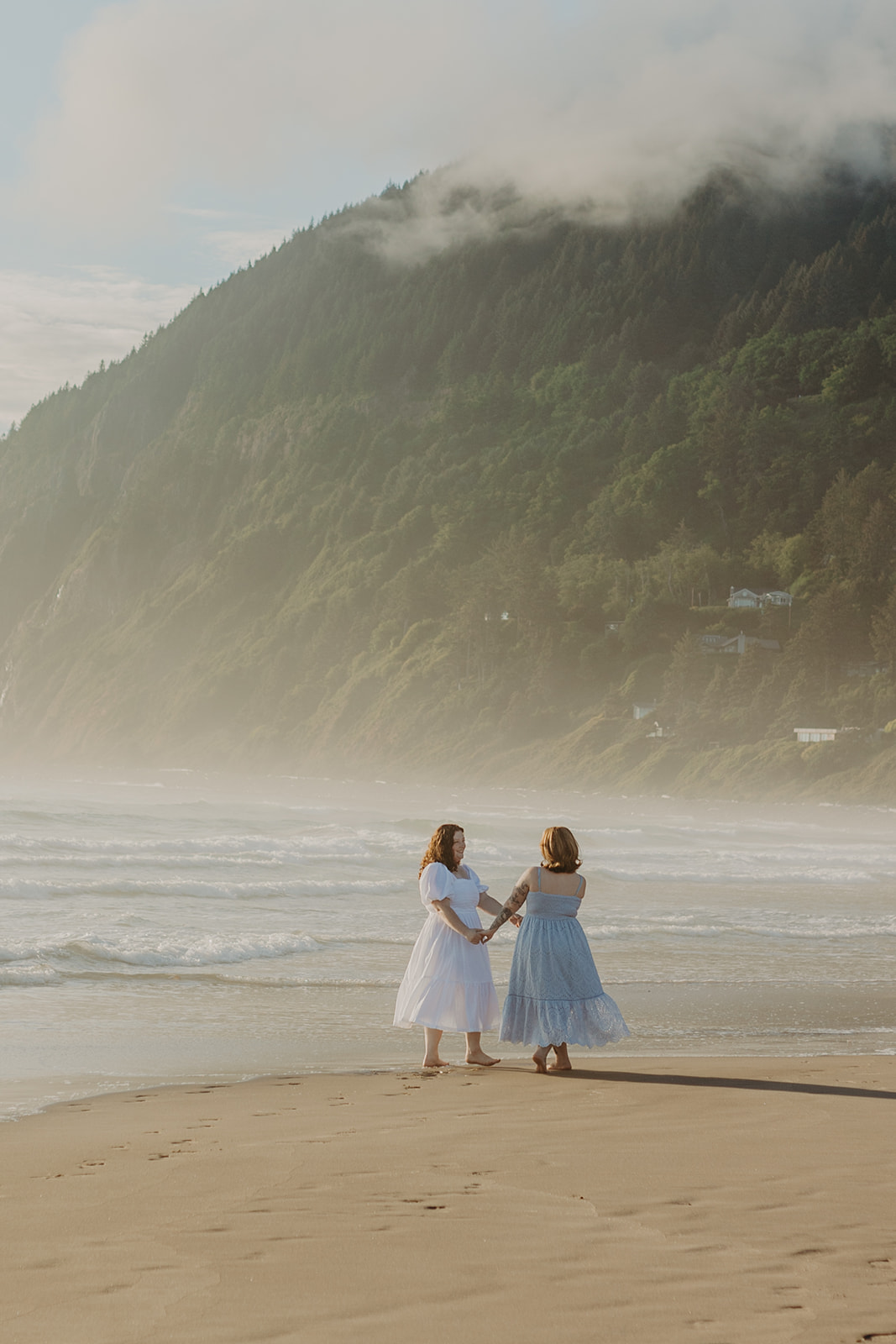 two women dance hand in hand on the Manzanita Beach 