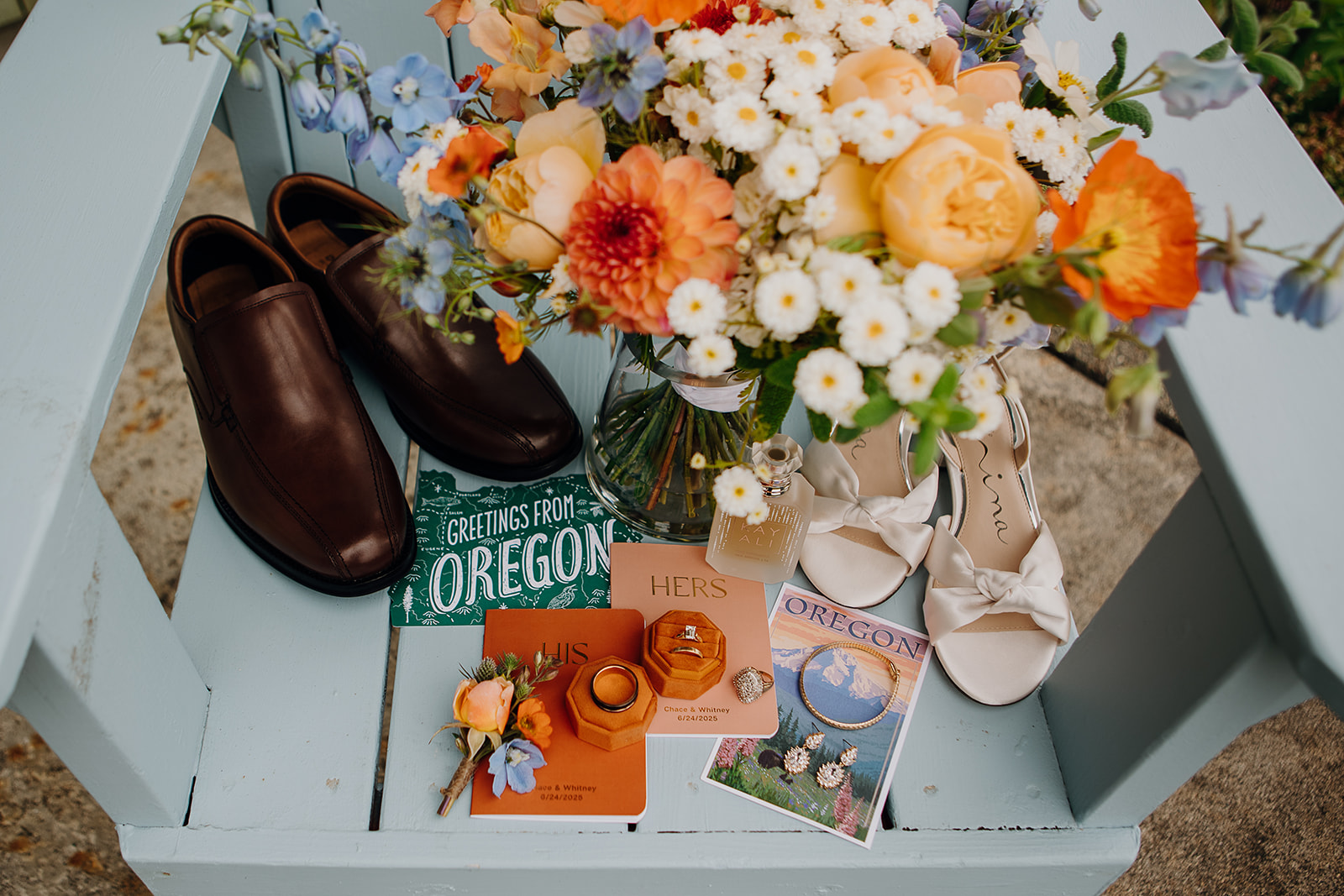 "Welcome to Oregon" wedding flat lay and details with rings, ring boxes, and wedding flowers. 