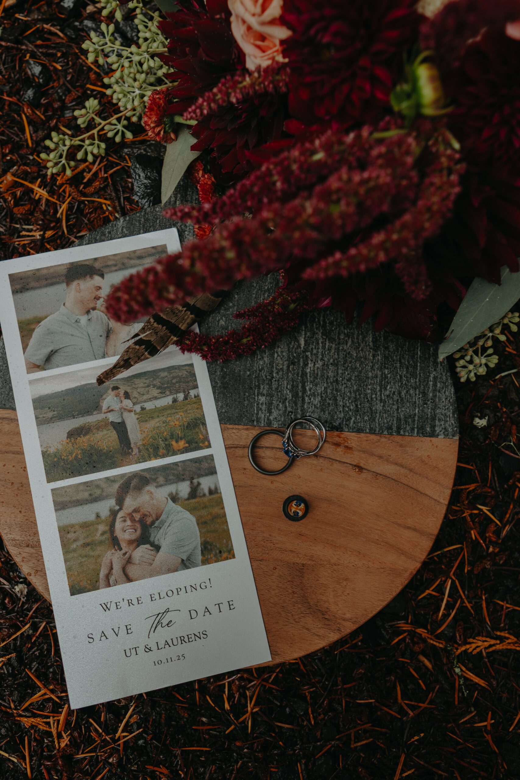 flatlay wedding details photos with rings, invitation, and bouquet on a wooden platter